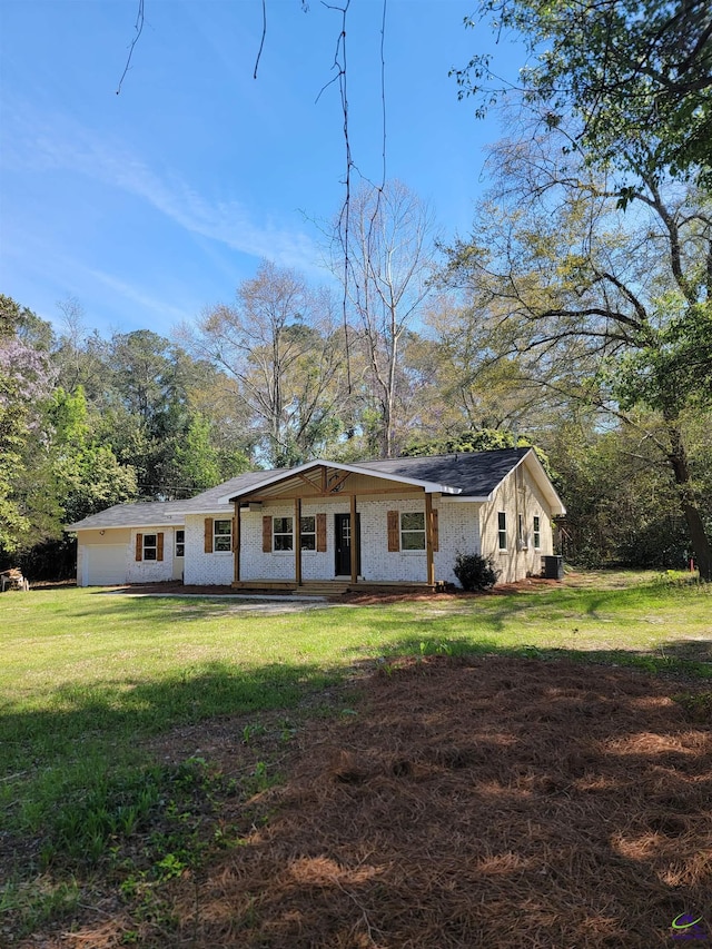 view of front of home with central air condition unit and a front lawn