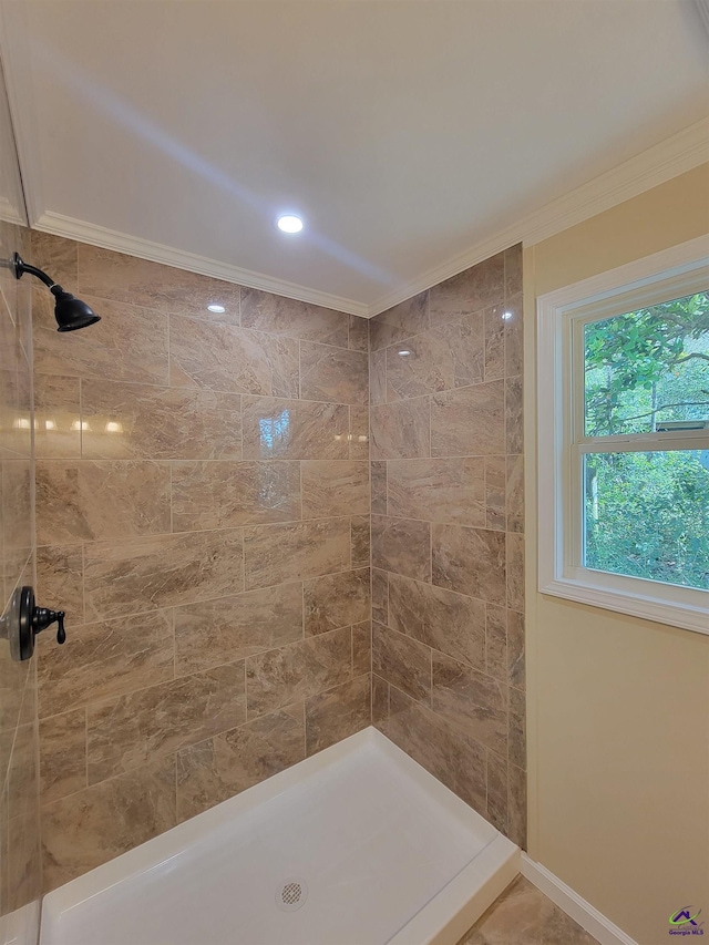 full bath featuring a tile shower and ornamental molding