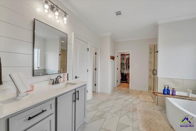 full bathroom featuring a freestanding tub, crown molding, a shower stall, a spacious closet, and marble finish floor