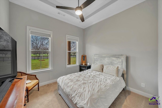 carpeted bedroom featuring baseboards, ceiling fan, visible vents, and crown molding