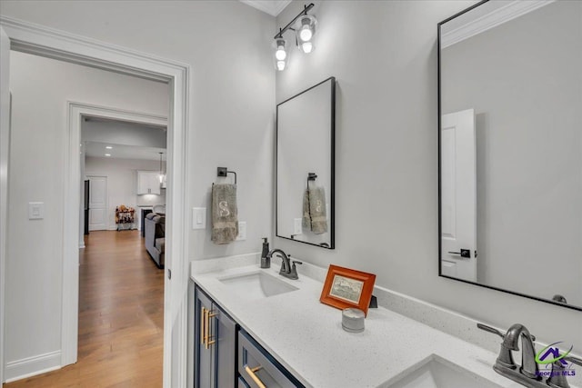 bathroom with ornamental molding, wood finished floors, and vanity