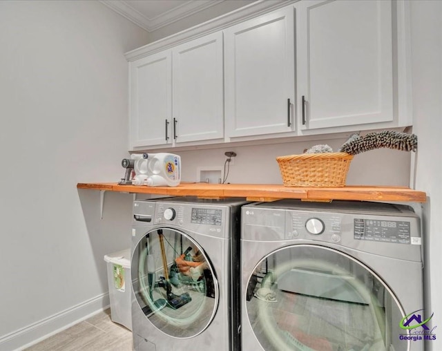 washroom with washer and clothes dryer, light wood finished floors, baseboards, cabinet space, and ornamental molding