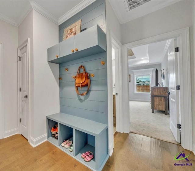 mudroom featuring baseboards, visible vents, light wood-style flooring, and crown molding