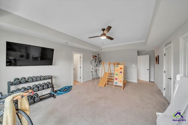 playroom with carpet flooring, a tray ceiling, baseboards, and ceiling fan
