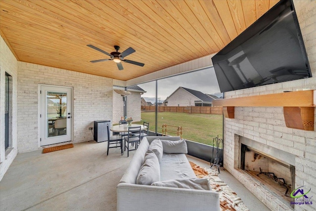 view of patio / terrace with ceiling fan, an outdoor living space with a fireplace, fence, and outdoor dining space