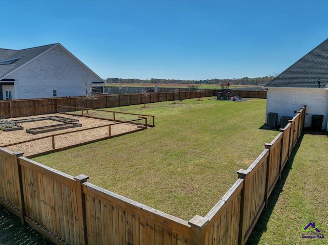 view of yard with central air condition unit and fence