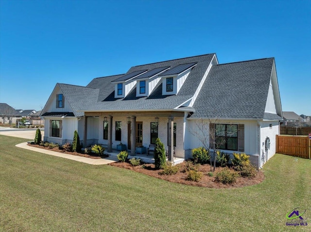 modern inspired farmhouse with a front yard, covered porch, and fence
