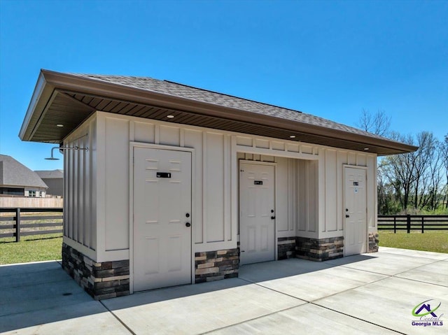 view of outbuilding featuring fence