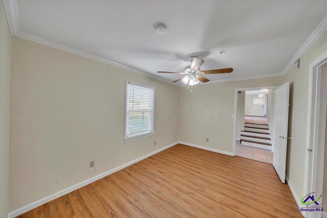 unfurnished bedroom with crown molding, baseboards, light wood-style floors, visible vents, and ceiling fan