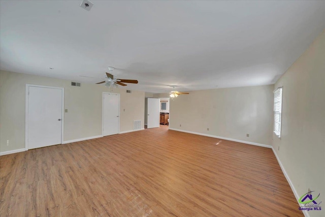 unfurnished living room with baseboards, visible vents, and light wood-type flooring