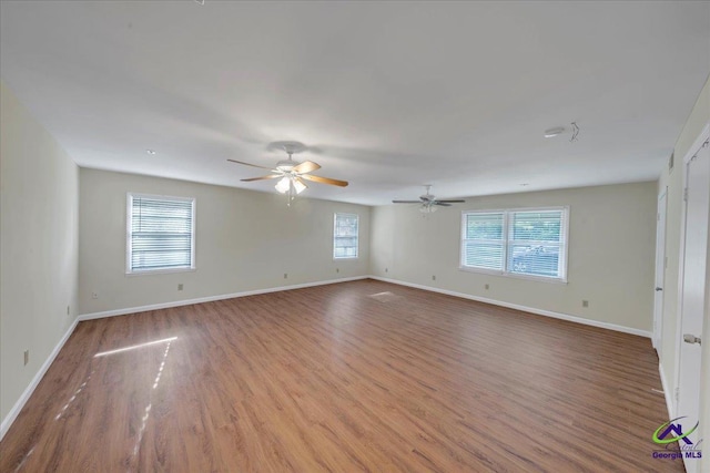 spare room featuring baseboards, ceiling fan, and wood finished floors