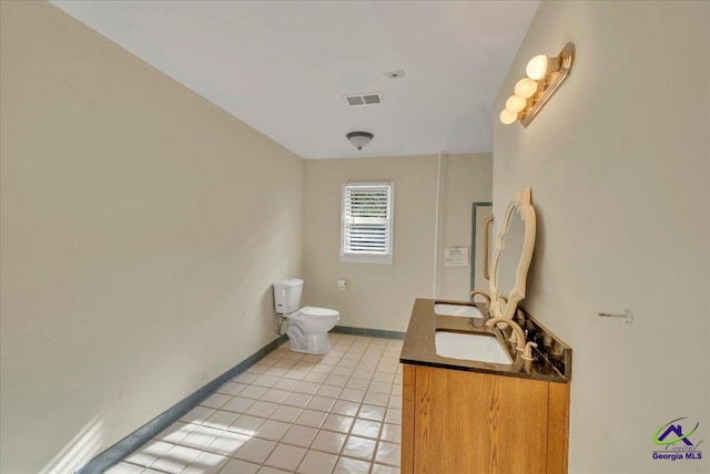 bathroom featuring toilet, a sink, tile patterned flooring, baseboards, and visible vents