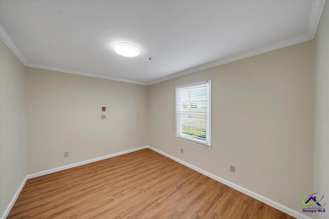 spare room featuring baseboards, crown molding, and light wood-style floors