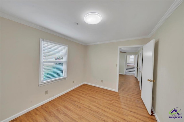 unfurnished room featuring baseboards, light wood-style flooring, a healthy amount of sunlight, and crown molding