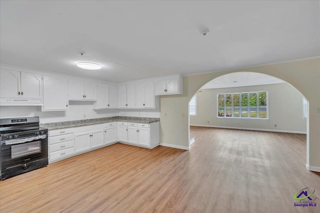 kitchen with arched walkways, under cabinet range hood, white cabinets, and electric range oven