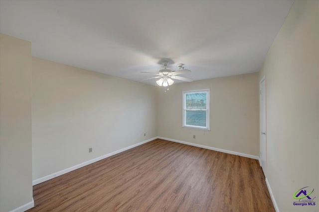 unfurnished room featuring baseboards, wood finished floors, and a ceiling fan