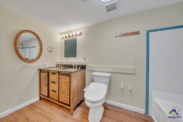 bathroom with toilet, visible vents, wood finished floors, and baseboards
