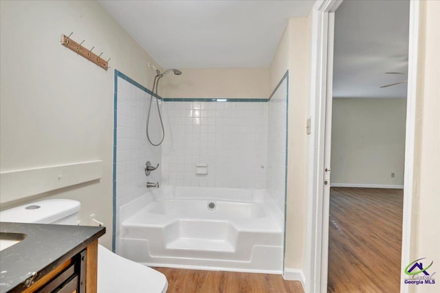 full bath featuring toilet, tub / shower combination, wood finished floors, and vanity