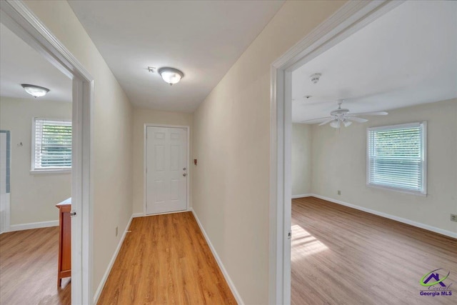 hallway featuring baseboards and light wood-type flooring