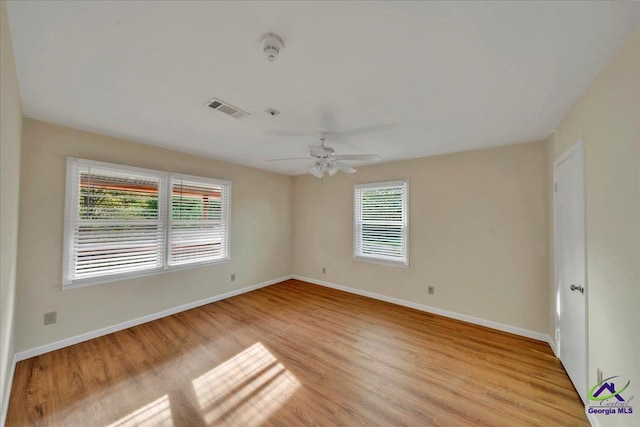 unfurnished room featuring ceiling fan, visible vents, a healthy amount of sunlight, and light wood finished floors