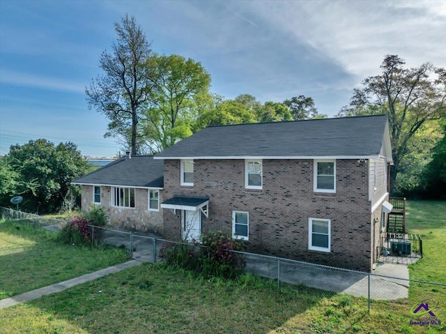 exterior space featuring brick siding, fence, and a lawn