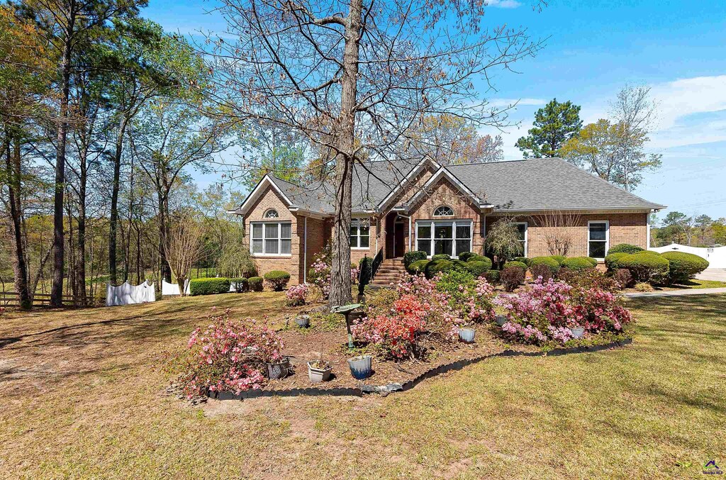 single story home featuring a front yard, fence, and brick siding