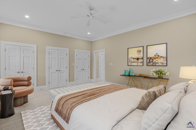 bedroom featuring multiple closets, crown molding, and light colored carpet