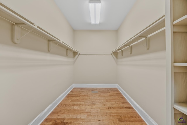 walk in closet with wood finished floors