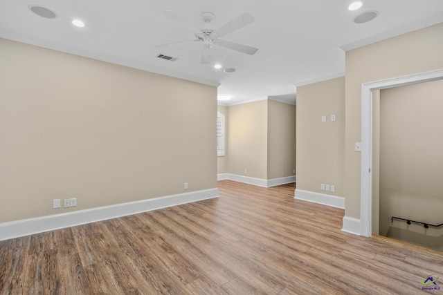 unfurnished room with baseboards, visible vents, crown molding, and light wood-style flooring
