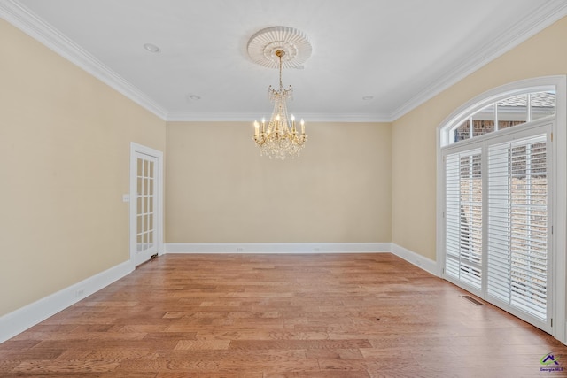 unfurnished room featuring an inviting chandelier, plenty of natural light, ornamental molding, and light wood-style floors