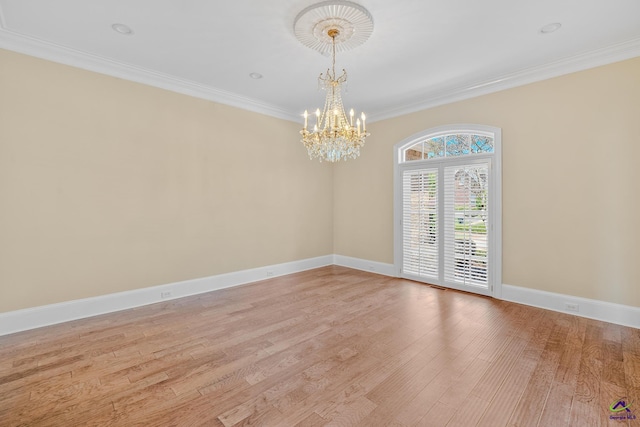empty room with light wood finished floors, crown molding, baseboards, and a chandelier