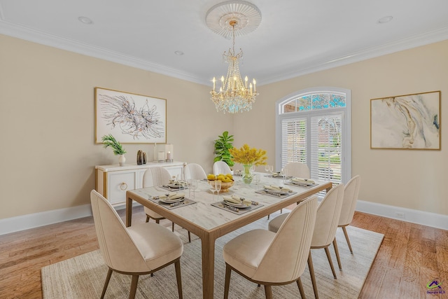 dining space featuring baseboards, ornamental molding, an inviting chandelier, and light wood finished floors