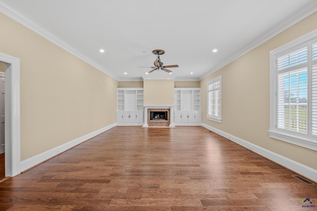 unfurnished living room with ornamental molding, baseboards, visible vents, a ceiling fan, and wood finished floors