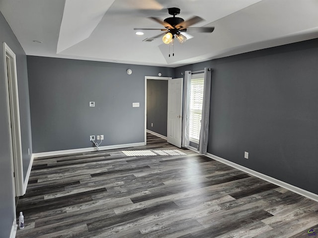 empty room with visible vents, baseboards, wood finished floors, and ceiling fan