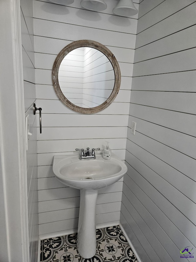 bathroom with tile patterned flooring and wooden walls