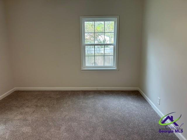 empty room featuring carpet flooring and baseboards