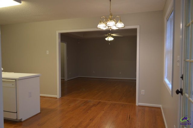 interior space with light wood-style flooring, ceiling fan with notable chandelier, and baseboards