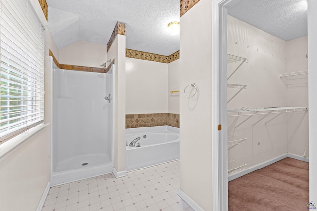 full bath featuring a stall shower, tile patterned floors, a walk in closet, and a textured ceiling