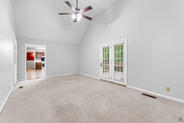 empty room featuring light carpet, high vaulted ceiling, ceiling fan, and visible vents