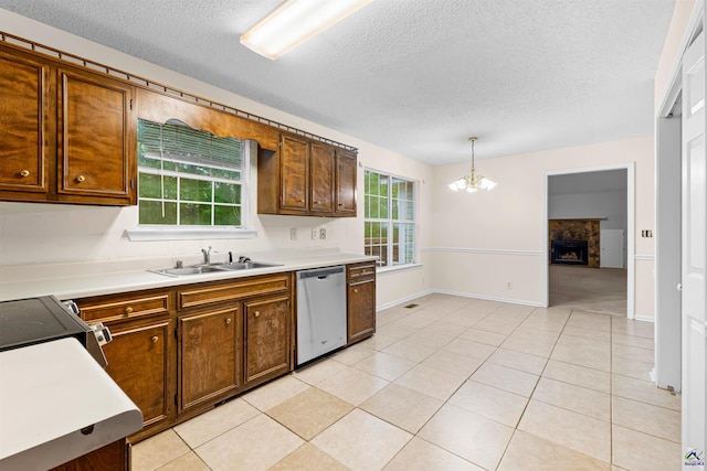 kitchen with a sink, a wealth of natural light, a notable chandelier, and dishwasher