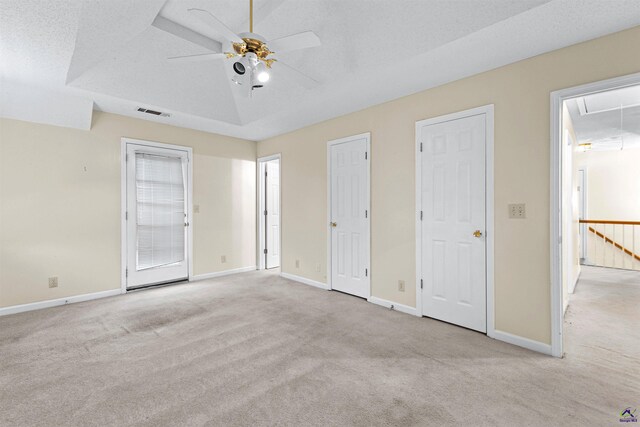 unfurnished bedroom featuring baseboards, attic access, carpet, and a textured ceiling