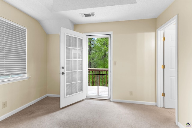 spare room featuring carpet, visible vents, baseboards, and a textured ceiling
