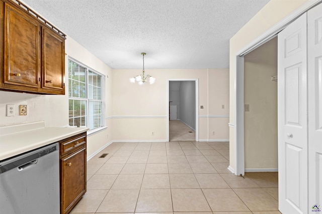 kitchen with a notable chandelier, light tile patterned floors, light countertops, a textured ceiling, and dishwasher