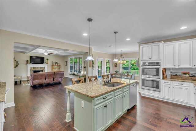 159 Feather Ln, Jackson, GA 30233 - kitchen featuring a fireplace, a ceiling fan, appliances with stainless steel finishes, a sink, and open floor plan