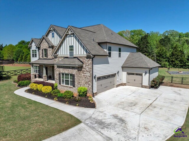 159 Feather Ln, Jackson, GA 30233 - view of front of home featuring a front yard, an attached garage, board and batten siding, fence, and concrete driveway