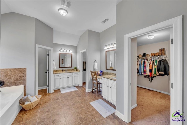 159 Feather Ln, Jackson, GA 30233 - bathroom with a walk in closet, visible vents, baseboards, and vaulted ceiling