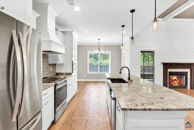 kitchen featuring plenty of natural light, an island with sink, a sink, and appliances with stainless steel finishes