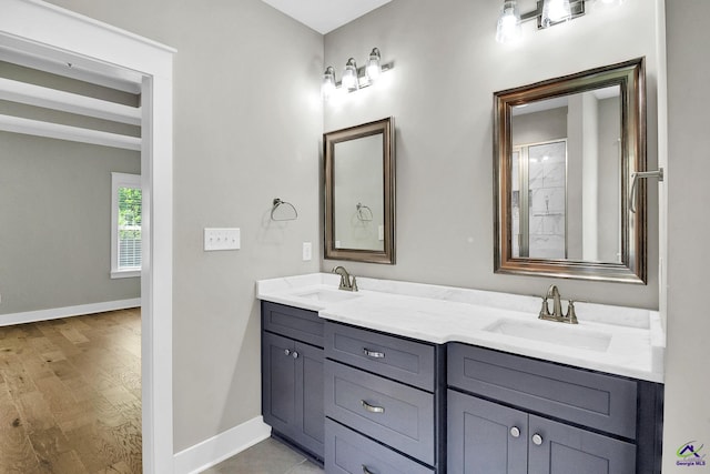 bathroom with double vanity, baseboards, and a sink