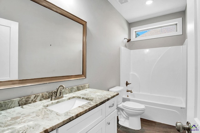 full bathroom featuring visible vents, shower / washtub combination, toilet, vanity, and wood finished floors
