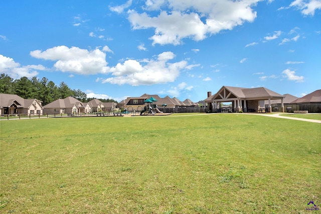 view of yard featuring a gazebo, playground community, a residential view, and fence